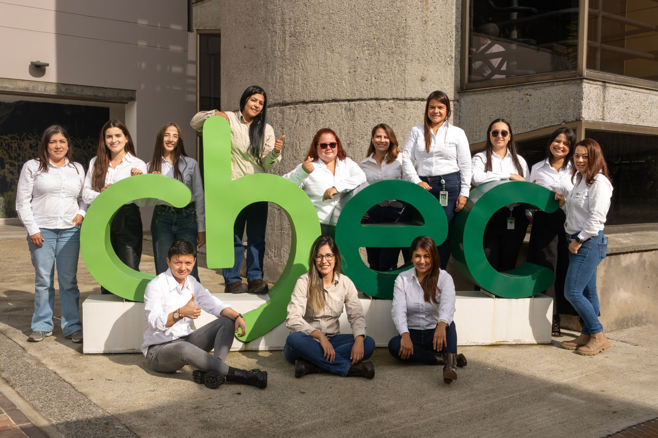 Empleadas de CHEC posando junto a su logo